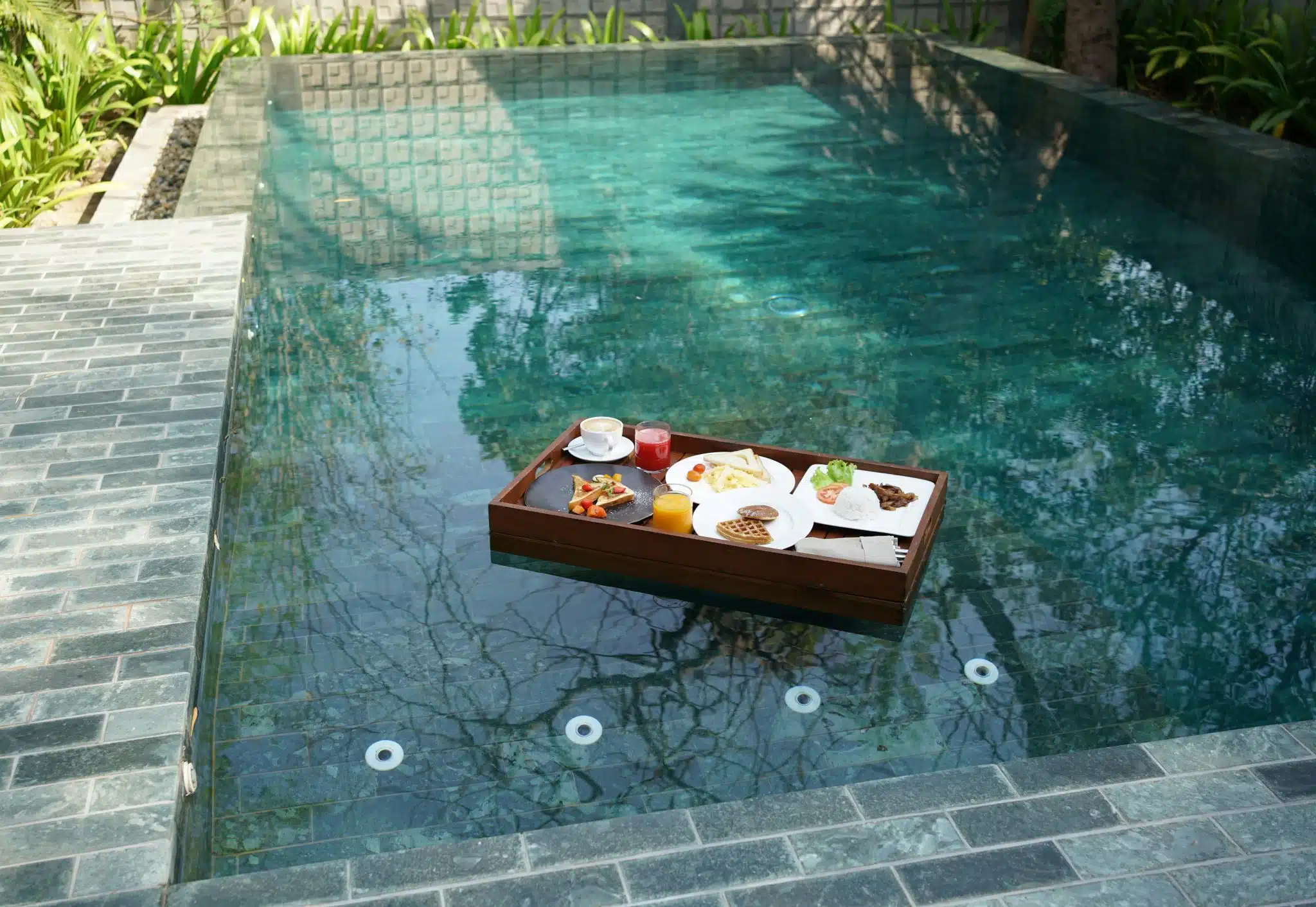 Petit-déjeuner dans un plateau sur la piscine, slow-life et farniente
