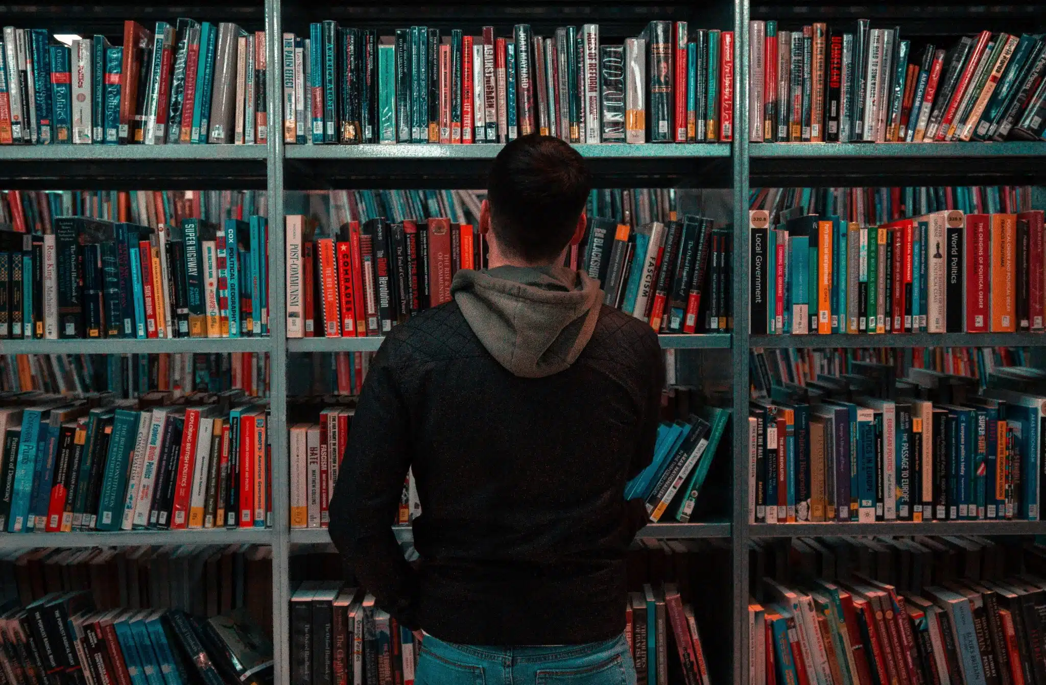 Homme devant une bibliothèque représentant le voyageur cultivé