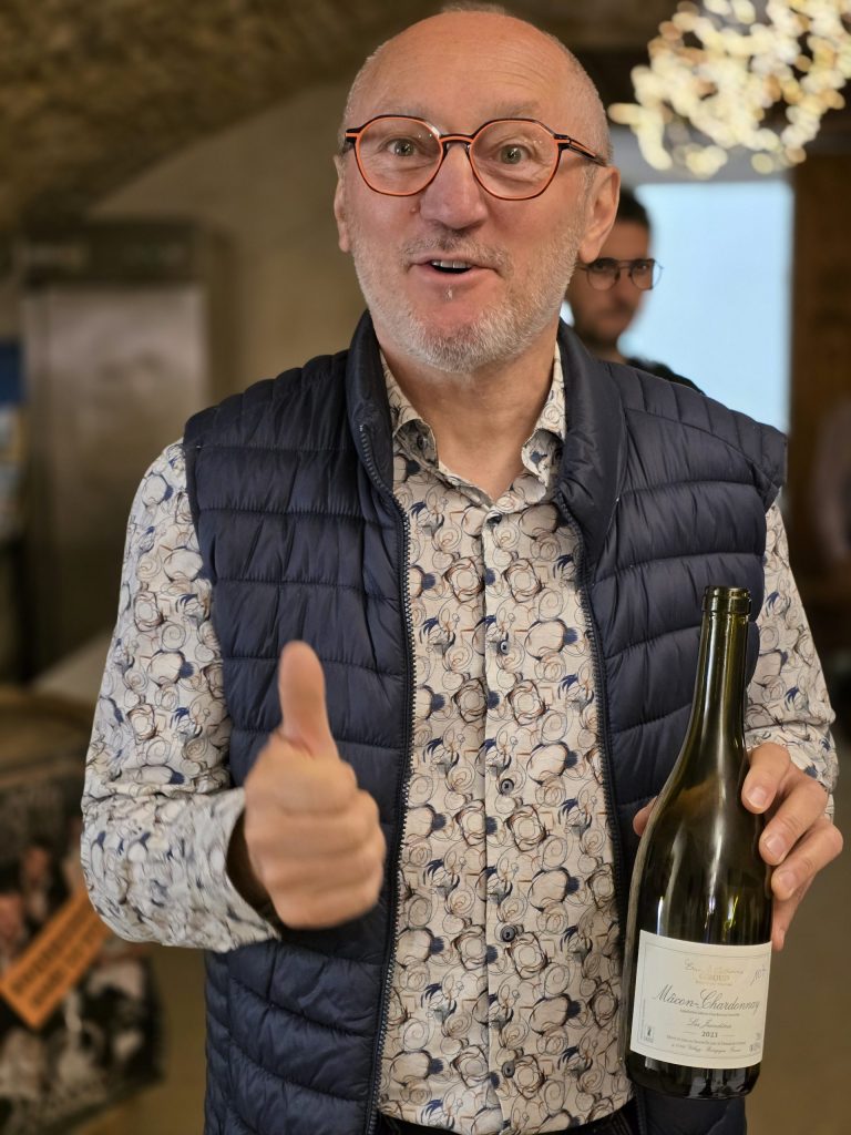 Jean-Claude Laugère montre la bouteille gagnante du concours Chardonnay Day 2025 "Les Jandières" Domaine Giroud